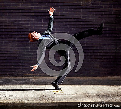 Theres no avoiding the banana skins in business. A young businessman tripping on a banana peel. Stock Photo