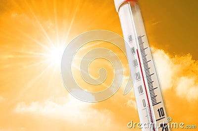 Thermometer against the background of an orange yellow hot glow of clouds and sun, concept of hot weather. Stock Photo