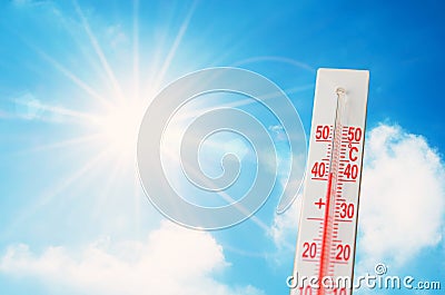 Thermometer is hot in the sky bright sun, glowing rays, concept of extreme weather Stock Photo