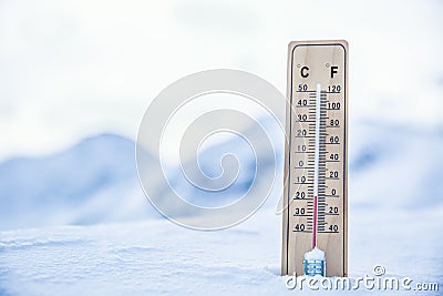 Thermometer on the mountains in the snow shows temperatures below zero. Low temperatures in degrees Celsius and fahrenheit Stock Photo