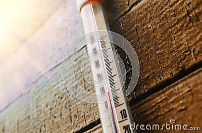 Thermometer on the old wooden wall, concept of autumn cool weather. Stock Photo