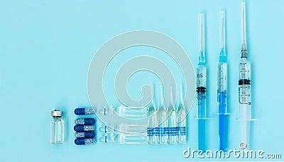 Thermometer, pills, injection ampoules, syringe for vaccination on a blue background, healthcare coronavirus, cancer, painand Stock Photo