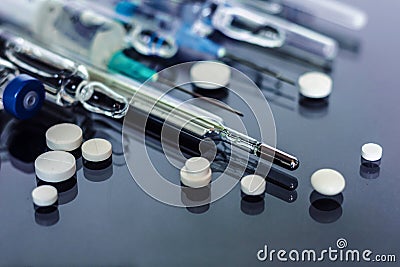 Thermometer, pills, injection vaccine ampoules, syringe for vaccination on glass background, Coronavirus, MERS-CoV, air Stock Photo