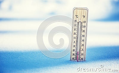 Thermometer on snow shows low temperatures under zero. Low temperatures in degrees Celsius and fahrenheit. Stock Photo