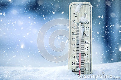 Thermometer on snow shows low temperatures - zero. Low temperatures in degrees Celsius and fahrenheit. Cold winter weather - zero Stock Photo