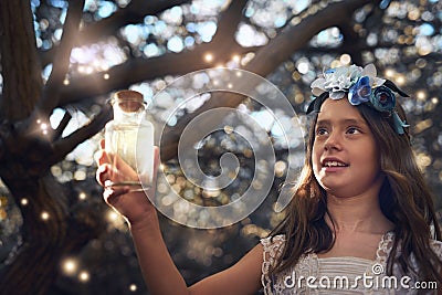 Theyre glowing just like fairies. a little girl catching fireflies in a jar outside. Stock Photo