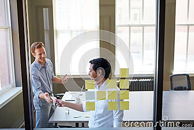 Theyre an ideally matched team. two businessmen preparing for a presentation by using adhesive notes. Stock Photo