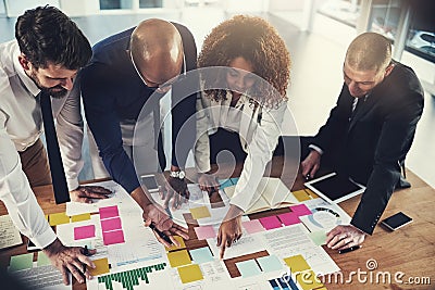 Theyve all got a keen eye for detail. a group of businesspeople going over paperwork during a meeting in their office. Stock Photo