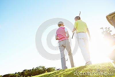 Theyve had a great game. Rear view shot of an elderly couple walking to their golf cart. Stock Photo