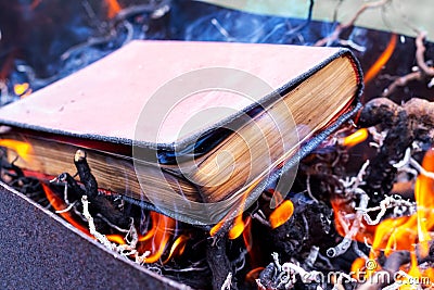 A thick book on fire. Burning books. Destruction of banned books Stock Photo
