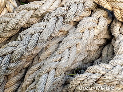 Thick braided rope is tied with a skein. Fishing rope background. Stock Photo