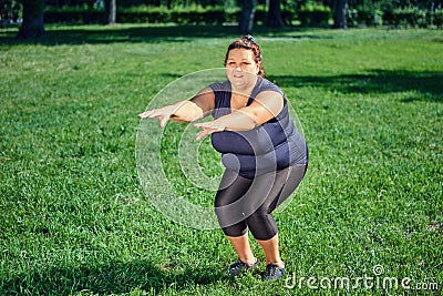 Thick caucasian woman doing gymnastic exercises in park. Stock Photo
