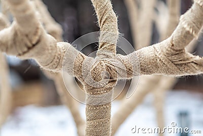 Thick fabric is tied around the branches of a wintery tree in the snow Stock Photo