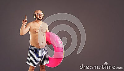 Thick funny man with a beard with a circle for swimming. Stock Photo