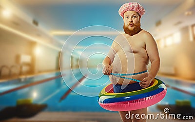 Thick funny man in the inflatable circle in the pool Stock Photo