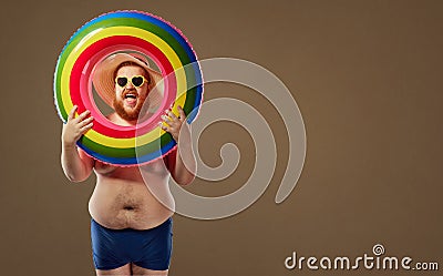 Thick funny man smiling in a swimsuit with an inflatable circle. Stock Photo