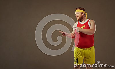 Thick funny man in sports clothes points with his finger. Stock Photo