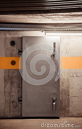 Thick metal hermetic door enter into nuclear fallout shelter built in basement Stock Photo