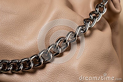 Thick shiny chain on brown leather Stock Photo
