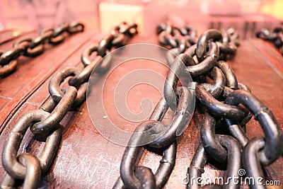 Thick, strong, iron, steel old chains against the background of an ancient wooden Stock Photo