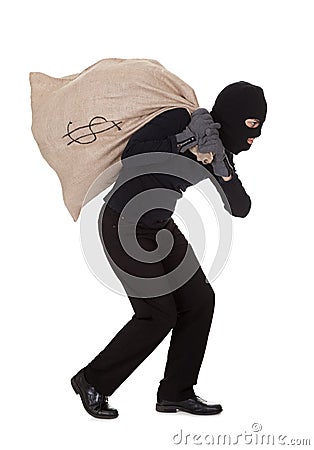 Thief carrying a large bag of money Stock Photo