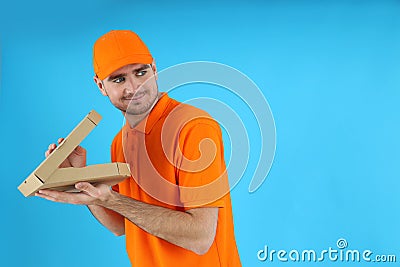 Thief delivery man with pizza on blue background Stock Photo