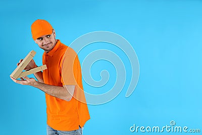 Thief delivery man with pizza on blue background Stock Photo