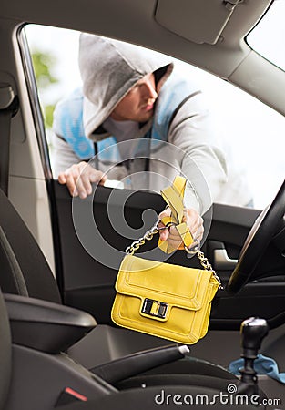 Thief stealing bag from the car Stock Photo