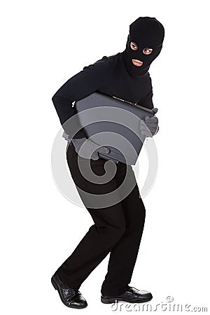 Thief stealing a laptop computer Stock Photo