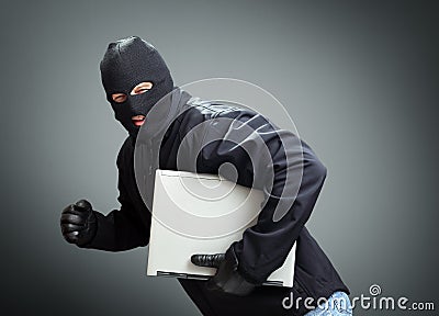 Thief stealing laptop computer Stock Photo