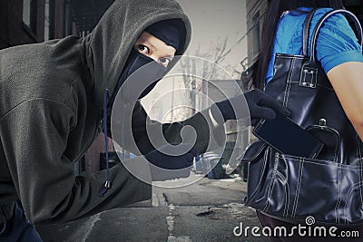 A thief stealing mobile phone Stock Photo