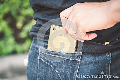 Thief is stealing smartphone from blue jeans pocket Stock Photo