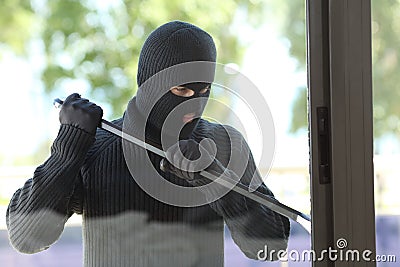 Thief trying to open a house window Stock Photo