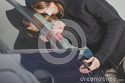 Thieft man holding screwdriver breaking into car Stock Photo