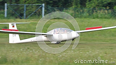 Glider just landed on a green grassy runway with spoilers open Editorial Stock Photo