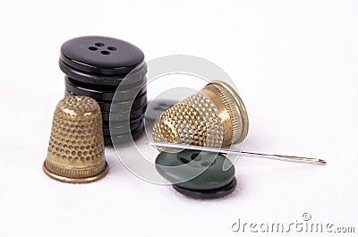 Thimble with a needle and black buttons Stock Photo