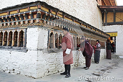 THIMPHU, BHUTAN - DEC 3, 2017: Pilgrims are spinning buddhist prayer wheels Editorial Stock Photo