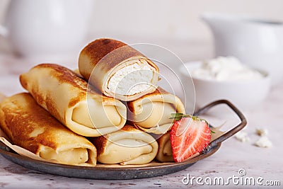 Thin crepe pancake rolls stuffed with cottage cheese Stock Photo