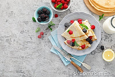 Thin crepes with fresh berries and lemon zest. Pancakes with raspberry and blackberry Stock Photo