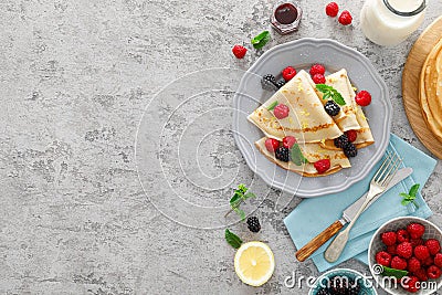 Thin crepes with fresh berries and lemon zest. Pancakes with raspberry and blackberry Stock Photo