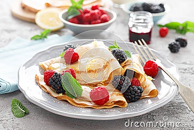 Thin crepes with fresh berries and lemon zest. Pancakes with raspberry and blackberry Stock Photo