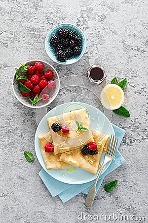 Thin crepes with fresh berries and lemon zest. Pancakes with raspberry and blackberry Stock Photo