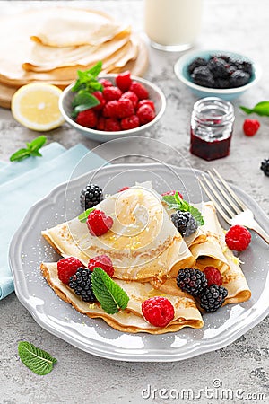 Thin crepes with fresh berries and lemon zest. Pancakes with raspberry and blackberry Stock Photo