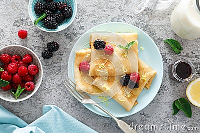 Thin crepes with fresh berries and lemon zest. Pancakes with raspberry and blackberry Stock Photo