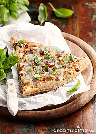 Thin-crust pizza topped with fresh basil leaves. Slice of pizza. Home made food. Italian vegetarian pizz Stock Photo