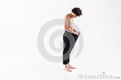 Thin guy standing with large trousers Stock Photo