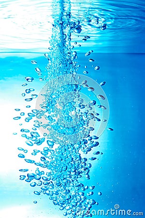 a thin jet of water penetrates the water surface Stock Photo