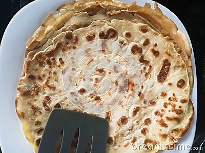 Thin pancakes stacked on a plate in a pile. Homemade pancakes Stock Photo