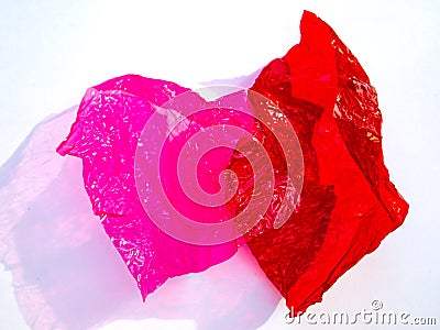 Thin sheet of multi coloured cellophane with shiny crumpled surface texture on white background, Abstract, Light & Shadow concept Stock Photo
