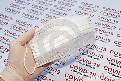 Thin white medical glove on hand and protective face masks on a COVID-19 background. Coronavirus protection concept. Stock Photo